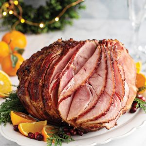 Spiral sliced Christmas ham with orange honey glaze on a serving plate