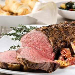 "SEVERAL MORE IN THIS SERIES. Prime beef tenderloin is barded with pork fat, tied, then cooked medium rare.  Roasted potatoes, crescent rolls, and sauteed chard accompany the roast beef.  Shallow DOF."
