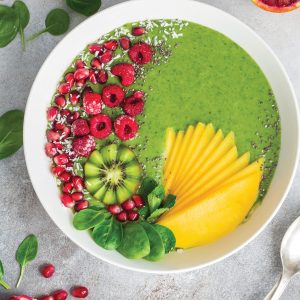 fresh green smoothie bowl with fruits and berries. Healthy vegan raw food. top view